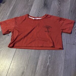 very cropped tee with the words “blue ocean bay honolulu” in top right corner